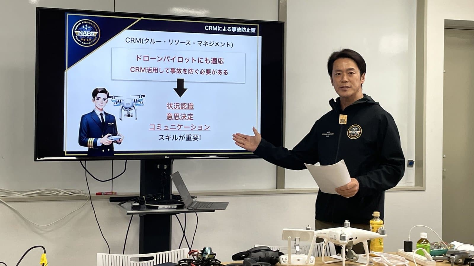 NAPAドローンアカデミーの学科の講習。講師がスライドで CRM(クルー・リソース・マネジメント)を説明している